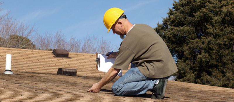 Man inspecting roof for damage