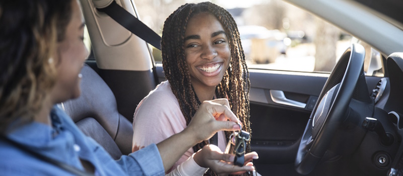 Mom handing her daughter the car keys